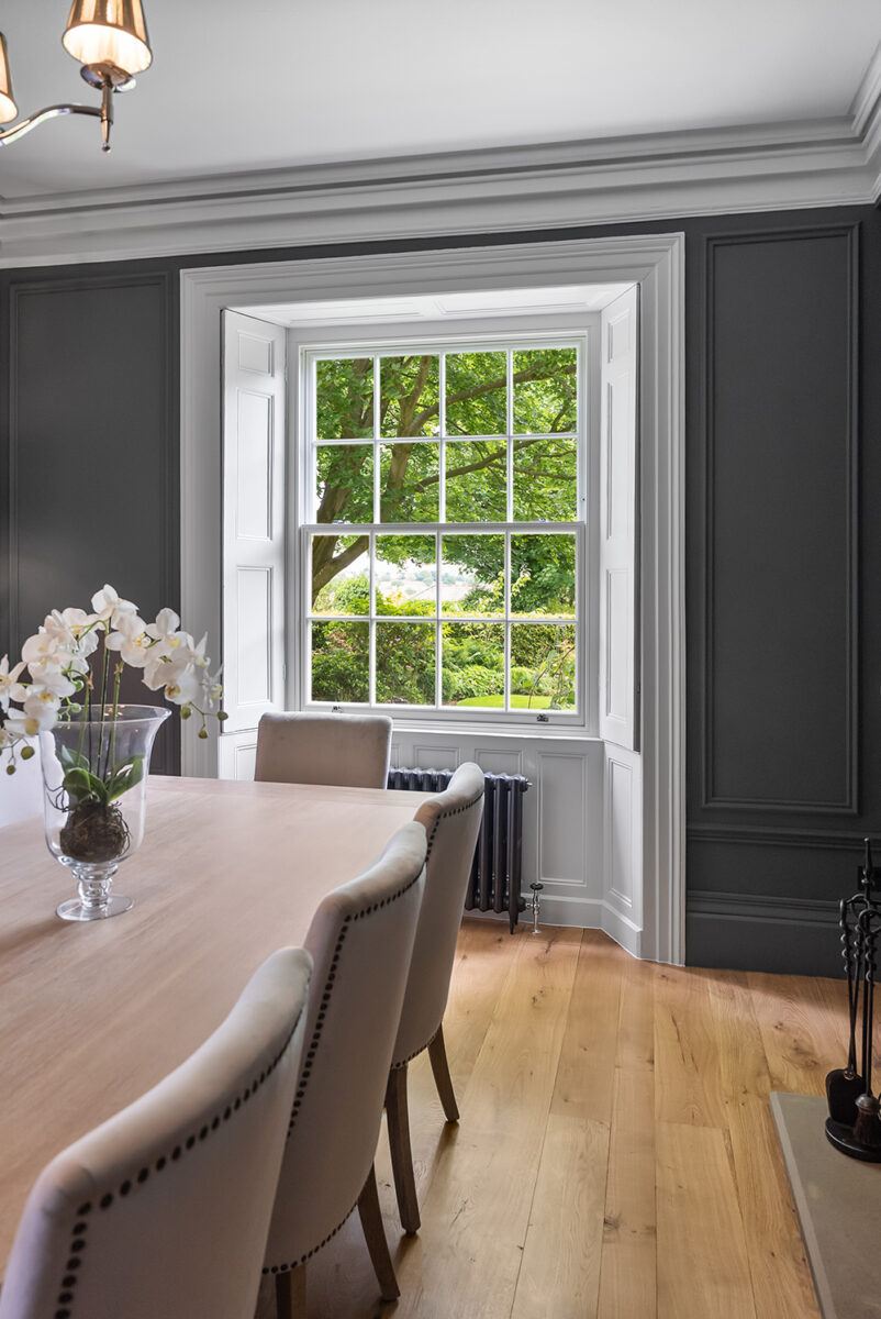 a dining room table in front of a georgian sash window