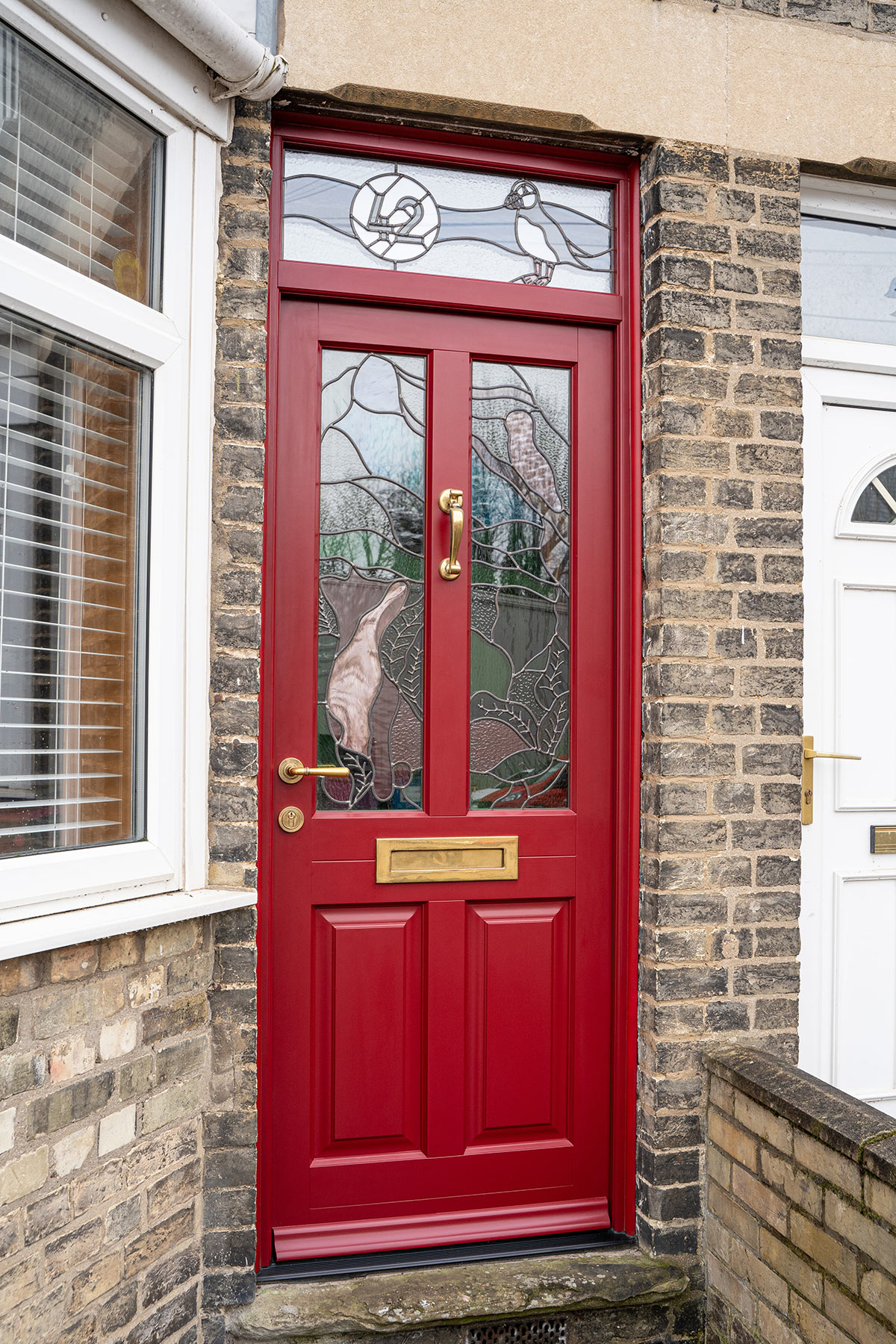 a red front door with animal theme stained glass