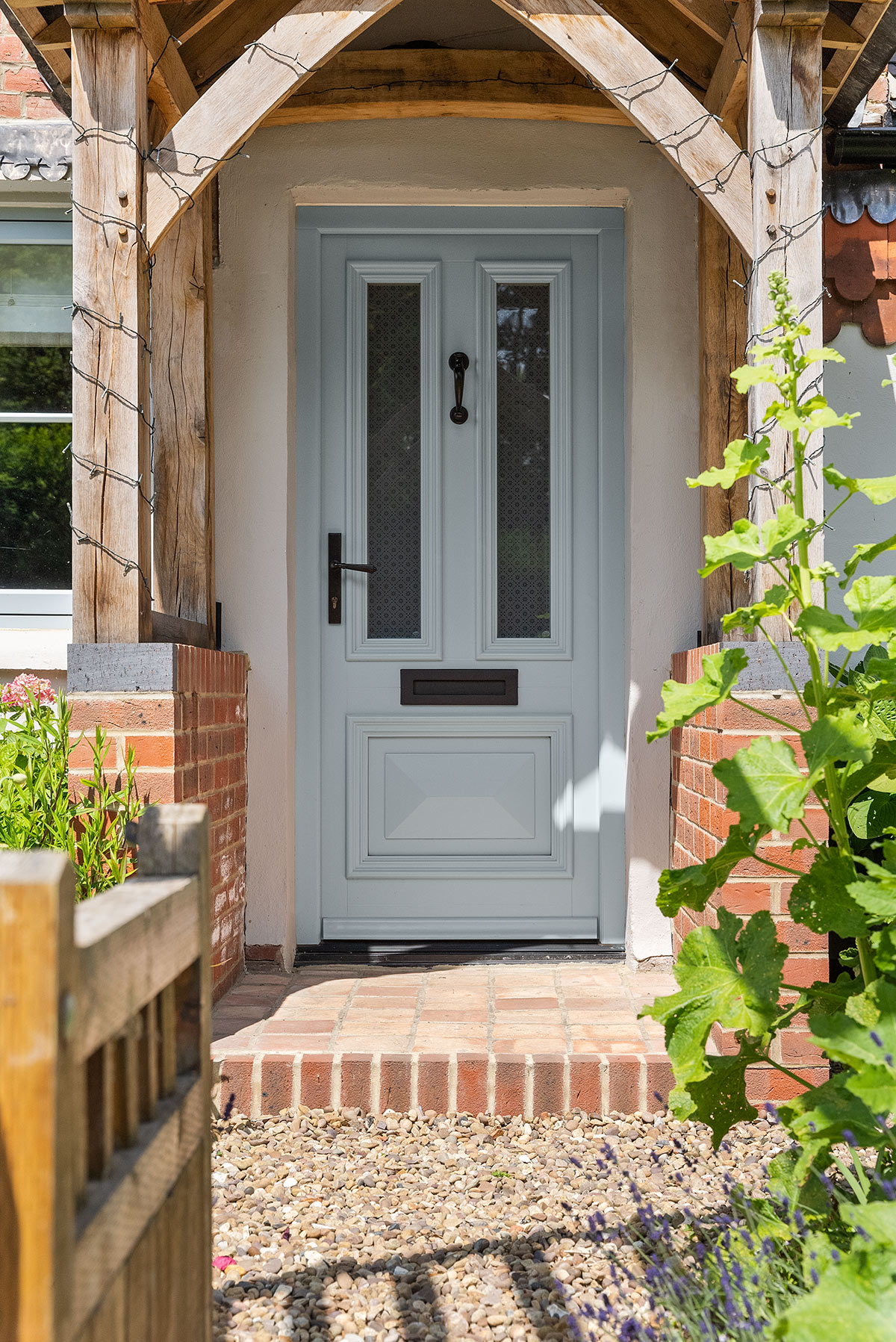 a light blue front door under a wooden canopy