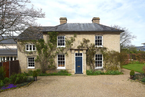 a georgian house with white windows and a blue door