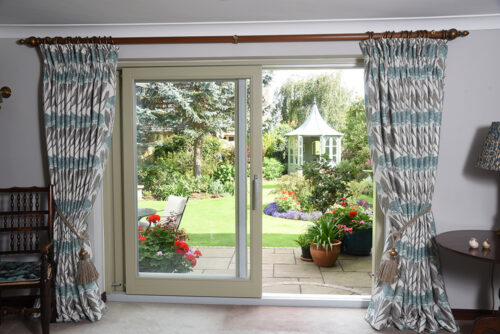 an open set of sliding doors opening onto a beautiful garden