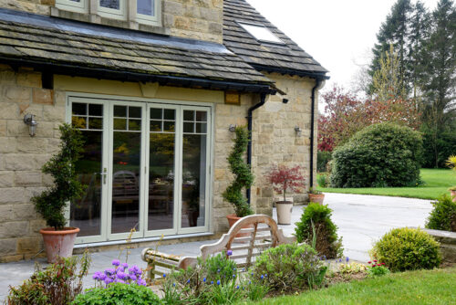 a set of french grey bi fold doors in front of a bench