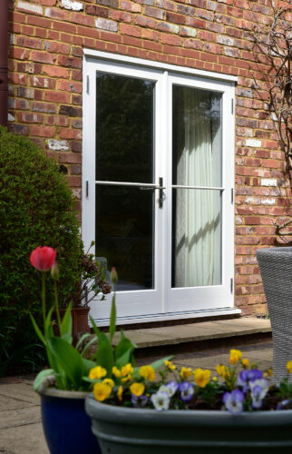 a set of white french doors on a red brick building
