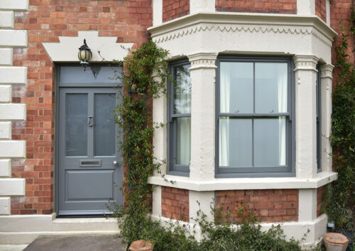 a townhouse with dark grey sash windows and front door