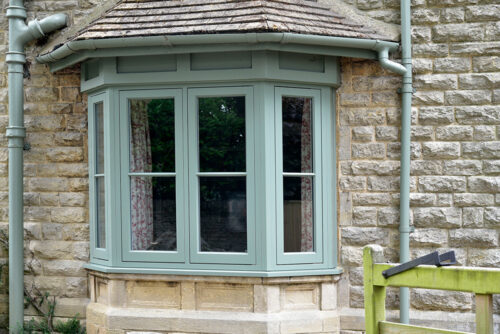 a bay window with flush casement windows in green finish