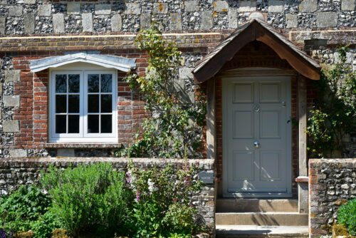 a georgian style front door next to a casement window