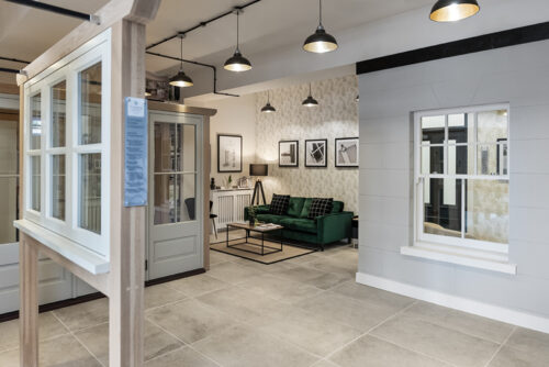 a windows and doors showroom with a green sofa
