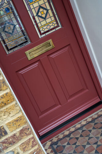 a red front door with bespoke stained glass
