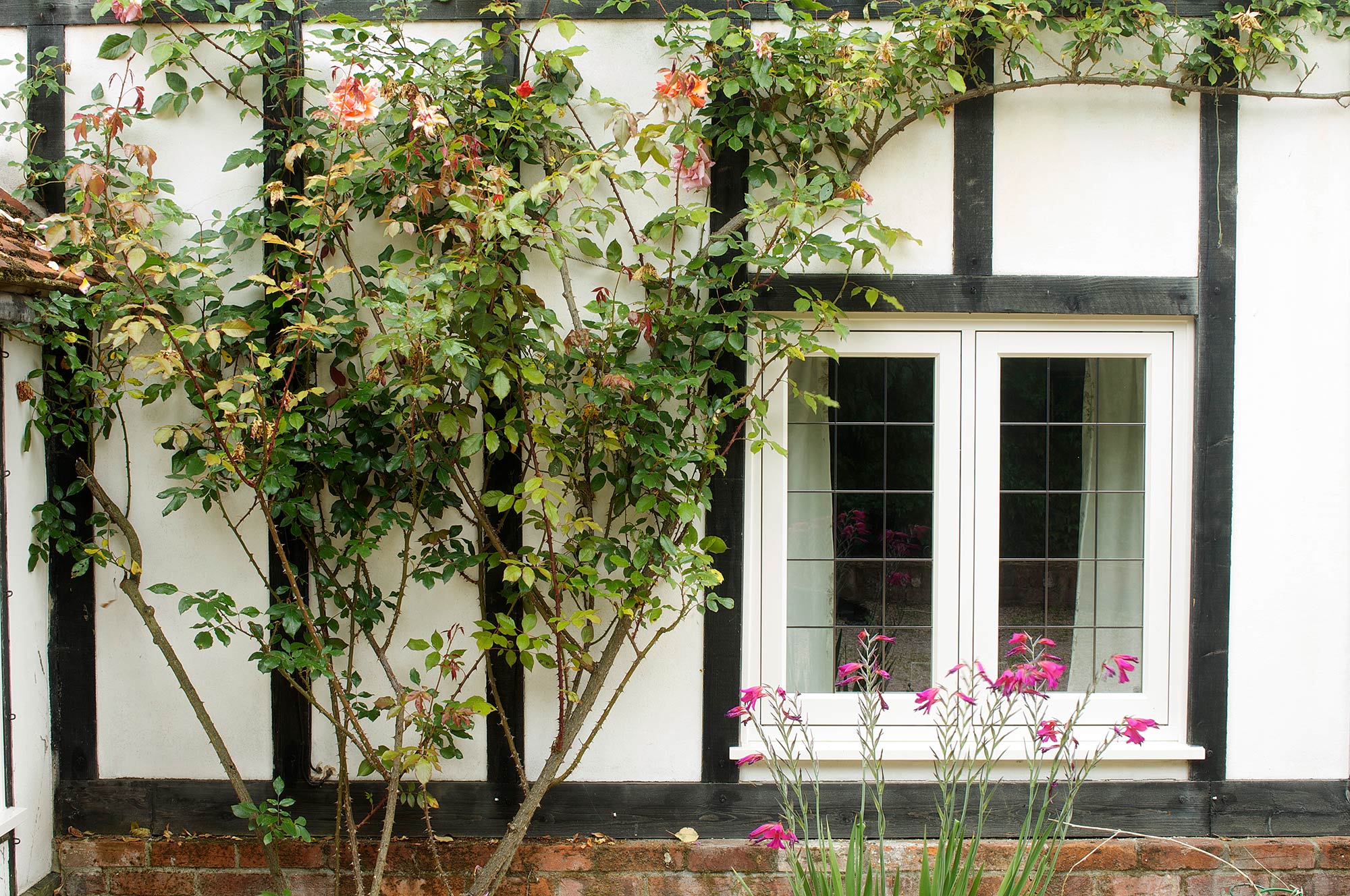 a white window with lead bars on a tudor property