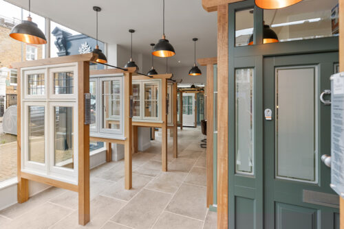 casement windows and a green front door on display in a showroom
