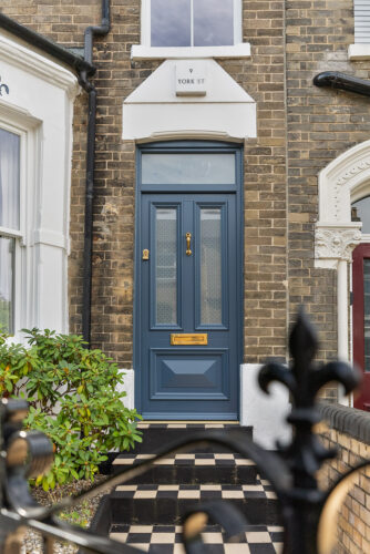 a blue traditional front door with etched glass