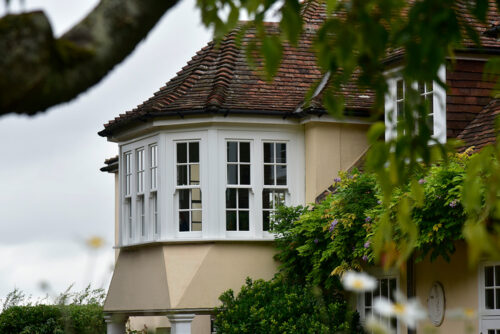 a large sash bay window on a yellow render property