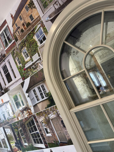 an arched sash window fixed into a wall with a vinyl graphic wallpaper