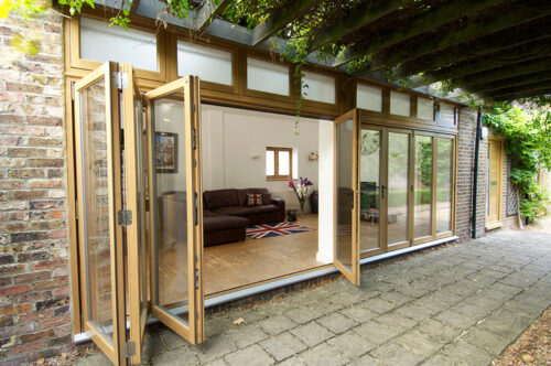 an oak stained set of bi fold doors opened and stacked