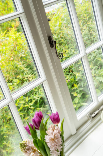 a white georgian casement window with a black monkeytail handle