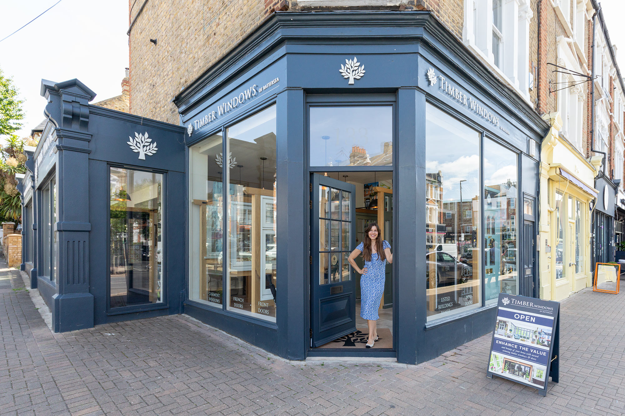 a lady stood in front of the timber windows of battersea showroom