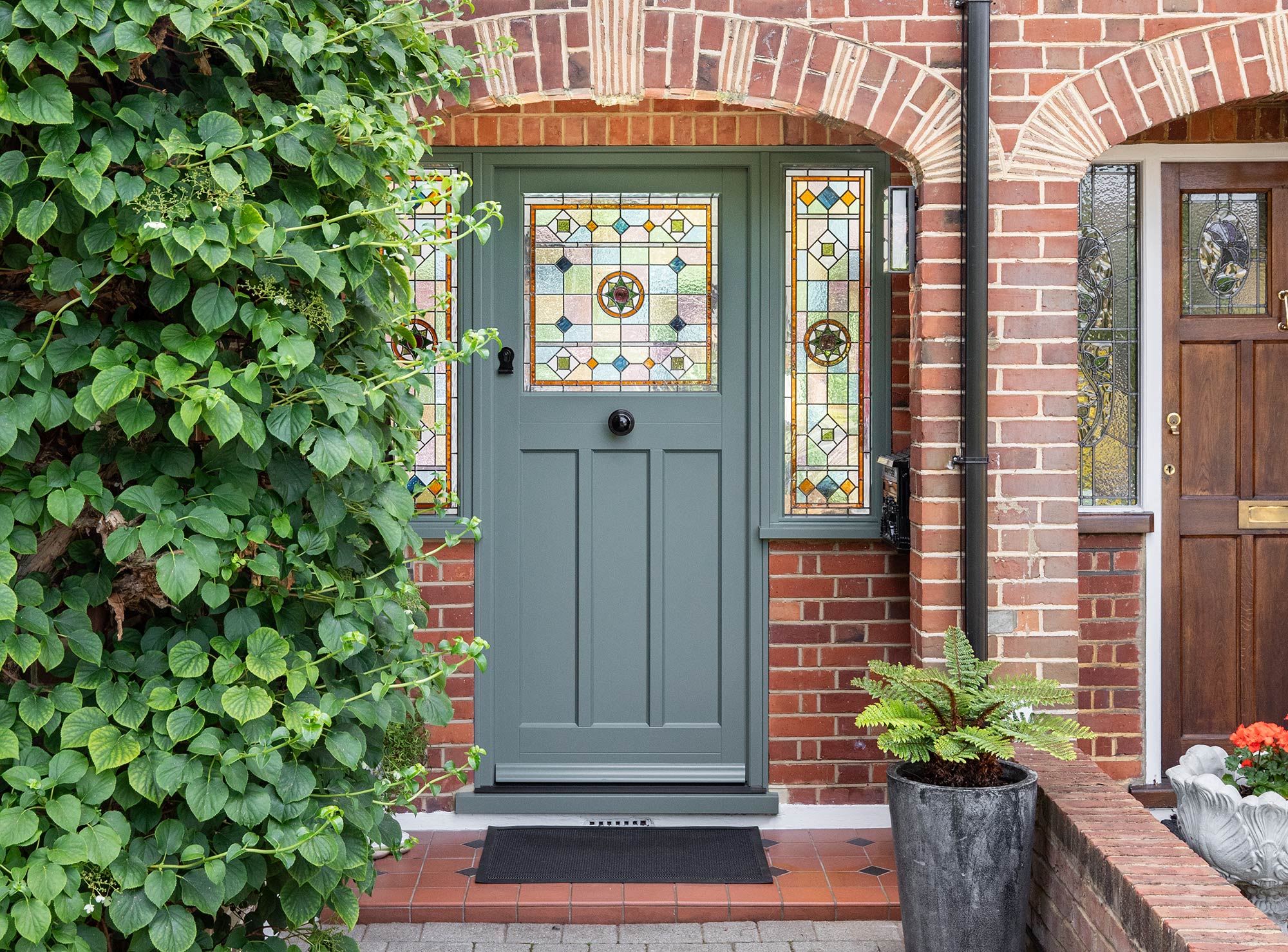 a green front door featuring a bespoke stained glass design