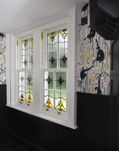box sash windows with stained glass, in a stylish room with monkey themed wallpaper