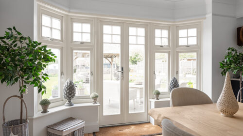 a dining room with timber french doors and casement windows
