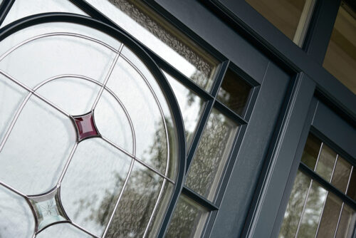 a dark timber front door with leaded glass and glazing bars. 