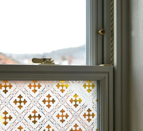 a sliding sash window with gothic etched glass